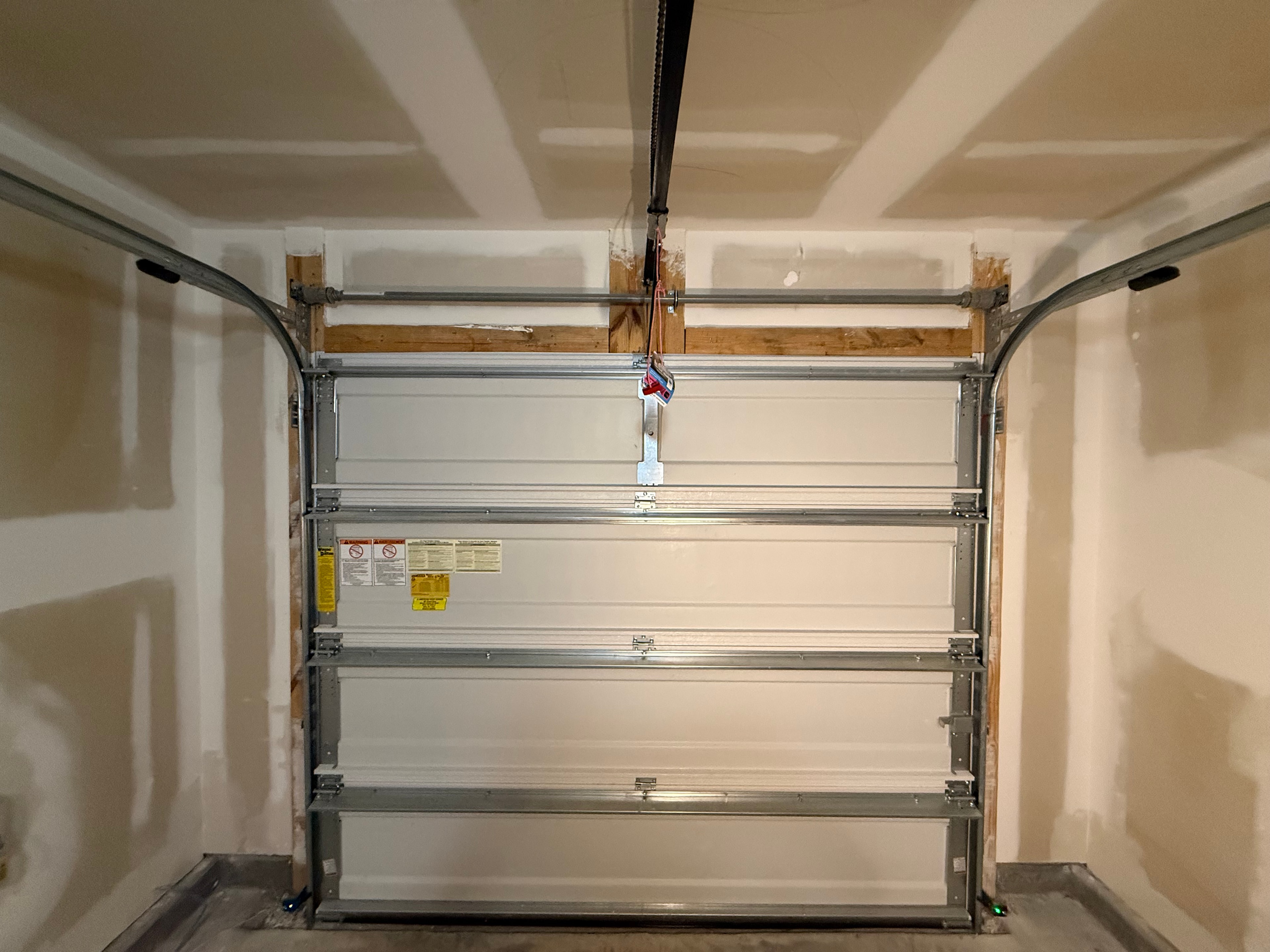 Unfinished garage interior with bare drywall before painting