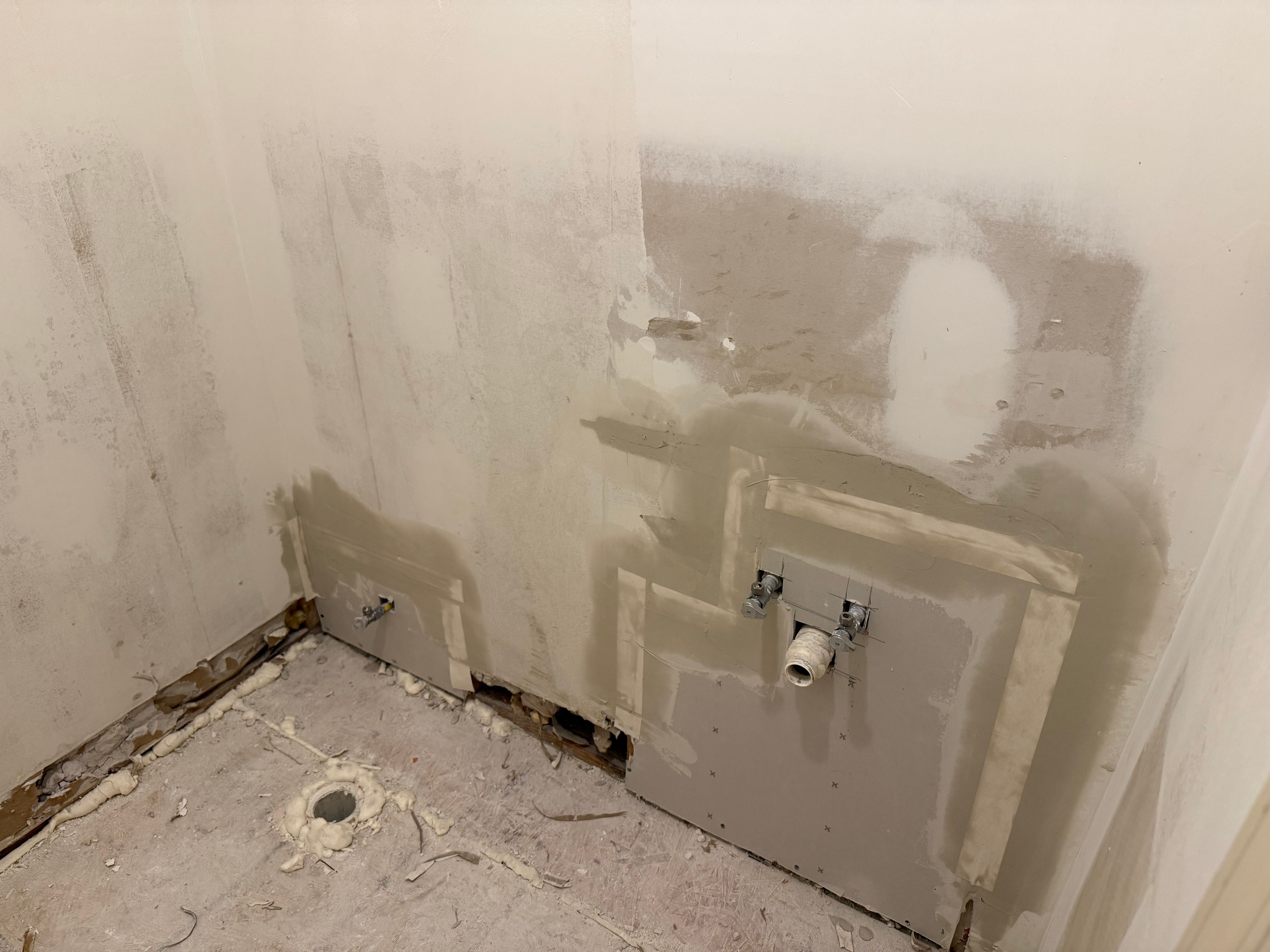 Drywall patches around drain pipes where vanity was replaced with pedestal sink